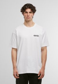 White cotton t-shirt with short sleeves, round neck, featuring black text "mijgonzales" on the left side. Plain design with no additional patterns.