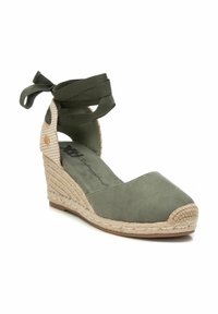 Espadrille de cuña verde de ante con suela de yute trenzado, con punta redondeada y cintas de tela envolventes en el tobillo. Decorado con un patrón de pata de gallo.