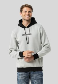 Hellgrauer Hoodie mit schwarzen Akzenten, vorderer Tasche und Kordeln. Mit "CIPO & BAXX" auf der Brust bedruckt. Weicher Stoff.