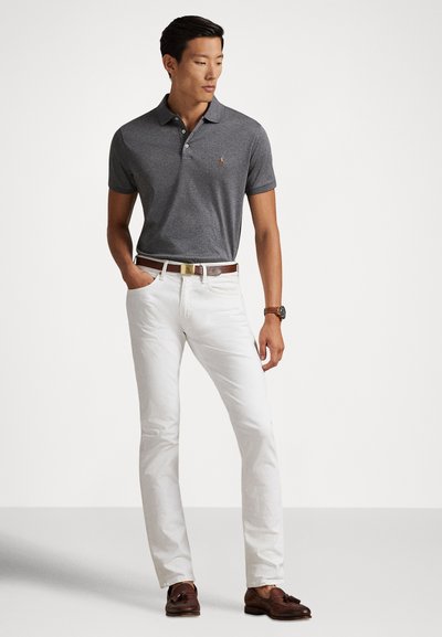 Pelēka īsām piedurknēm polo krekls ar nelielu logotipu, kopā ar baltām biksēm un brūnu ādas jostu. Brūni loafers noslēdz tēlu.