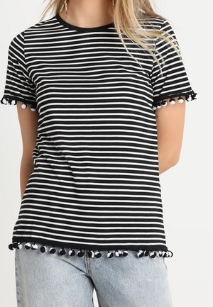 Czarna i biała koszulka w paski z krótkimi rękawami, ze zdobieniem z pomponów na dole i okrągłym dekoltem.