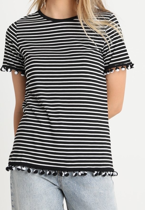 Camiseta de rayas blancas y negras con mangas cortas, con un borde de pompones en el dobladillo y un cuello redondo.