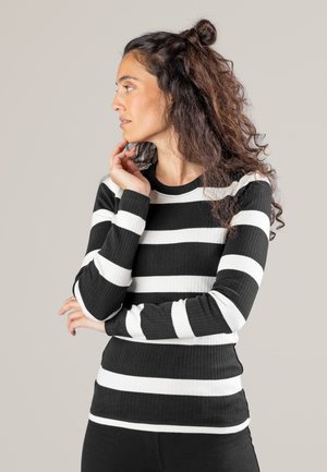 Gestreifter, schwarz-weißer, gerippter Pullover mit langen Ärmeln und rundem Ausschnitt. Der Stoff hat eine weiche Textur mit abwechselnd breiten Streifen.