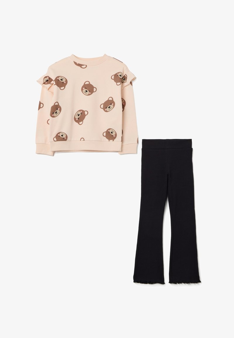 Lichtroze longsleeve sweatshirt met bruine berenprints en geplooide schouders, gecombineerd met zwarte flared leggings met een ruwe zoom.