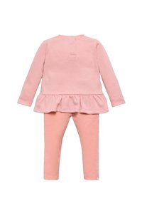 Conjunto de dos piezas de algodón rosa que incluye una camiseta de manga larga con un dobladillo con volantes y leggings de canalé a juego. Cierre de botón en la parte posterior.