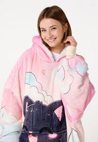 Gezellige roze oversized hoodie-deken met een zachte, pluche textuur, wolkenpatronen en een afbeelding van een zwarte kat aan de voorkant.