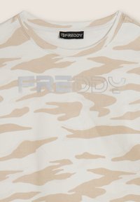 T-shirt beige con motivo camouflage realizzato in tessuto morbido, con scollatura tonda e la scritta "FREDDY" in lettere argento riflettenti.