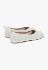 Bílé perforované baleríny s kulatou špičkou, jemným podpatkem a poutkem vzadu. Měkký materiál a minimalistický design.