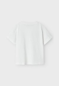 Camiseta blanca lisa de manga corta vista desde atrás sobre un fondo gris claro.