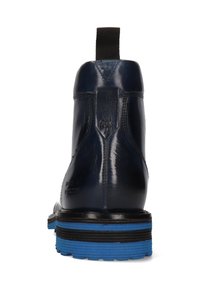 Bota de cuero azul marino con suela negra y azul, tira de agarre negra en la parte posterior y detalles de costura a lo largo del tacón.