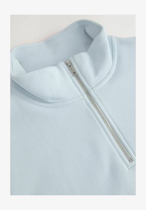 Hellblaue Zip-Kragen-Sweatshirt aus weichem Stoff, mit einem hohen Kragen und einem silbernen Reißverschluss auf der Vorderseite, mit minimalen Nähdetails.