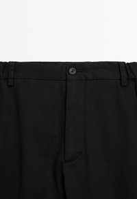 Black trousers with a button closure, elastic waistband, and a smooth texture. Features include belt loops and a side pocket.