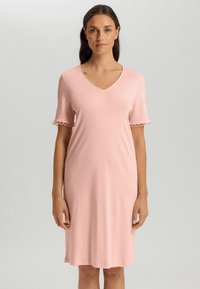 Abito rosa, lungo fino al ginocchio, realizzato in un tessuto morbido. Presenta un scollo a V e maniche corte con dettaglio a onda ai polsini. Design semplice e aderente.