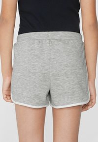 Pantaloni corti grigi in cotone con una texture morbida, caratterizzati da una bordatura bianca lungo l'orlo e tasche laterali, mostrati da dietro.