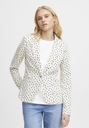 White blazer with black heart pattern, tailored fit, single-button closure, and side pockets, worn over a white t-shirt and jeans.