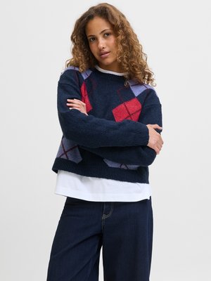 Granatowy, dzianinowy sweter o kroju cropped, z diamentowym wzorem w kolorze czerwonym i jasnofioletowym. Miękka tekstura z okrągłym dekoltem.