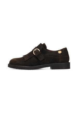 Donkerbruine suède loafer met franjes, een brede gespband en lage zwarte hak, zijaanzicht op een witte achtergrond.