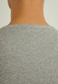 Tricou gri cu gât rotund și mâneci scurte, prezentând un detaliu cusut subtil pe spate și o textură moale și netedă.