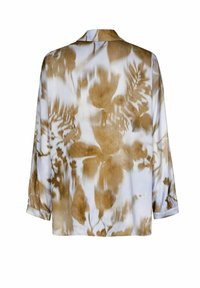 Bloes met bloemmotief in lichtcrème met bruine accenten, met een relaxte pasvorm, kraag en lange mouwen. Zachtheid van de stof.