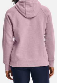 Huppari vaaleanpunaisena, jossa on teksturoitu pinta, raglanhihoilla, ribattuilla hihoilla ja helmakohdilla, esittelee rentoa istuvuutta.