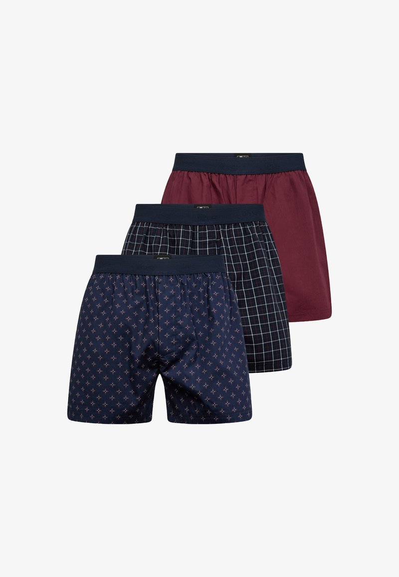 Tre par herreboxershorts: en mørkeblå med små geografiske mønstre, en bordeauxrød og en mørkeblå med ternet design. Alle har elastiske taljebånd.
