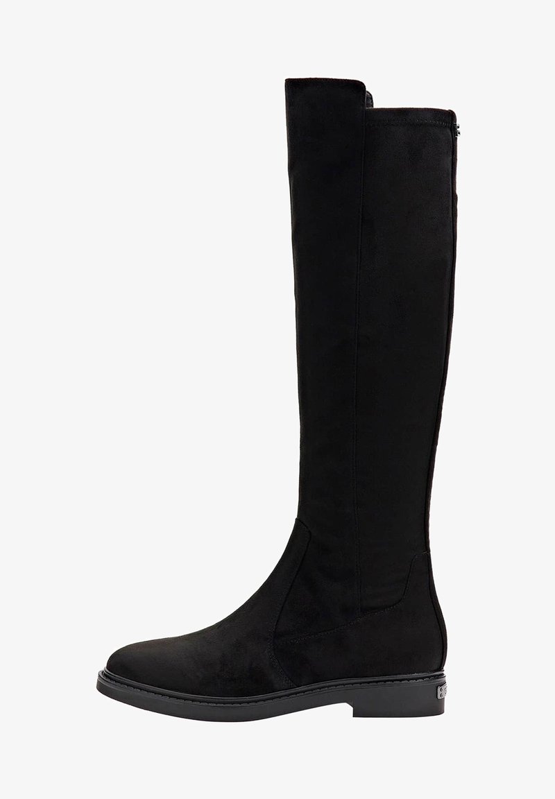 Polvisteiset mustat saappaat pehmeästä mokasta, joissa on sivuvetoketju ja litteä pohja, jossa on hienovarainen ommeltu yksityiskohta reunan ympärillä.