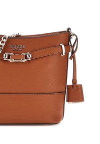 Borsa a spalla in pelle marrone con hardware argentato, tracolla a catena e un piccolo etichetta. Presenta una finitura testurizzata e dettagli di cucitura orizzontale.