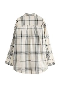 Långärmad skjorta med knapplås i svart och grå rutmönster på vit tyg, visad bakifrån mot en vit bakgrund.
