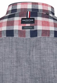 Geruite shirt in rood, wit en marineblauw met een effen marineblauwe achterkant. Heeft een label met "Hechter Paris" en "Regular Fit." Van katoen.