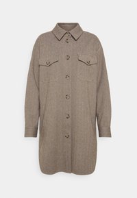 Brun herringbone skjortjacka med långa ärmar, knappstängning framtill, två bröstfickor och klassisk krage. Strukturerad tyg.