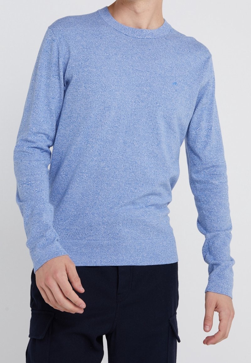 Jasnoniebieski sweter z długim rękawem wykonany z teksturowanej dzianiny, z okrągłym dekoltem i dopasowanymi mankietami, z subtelnymi różnicami koloru na całej powierzchni.