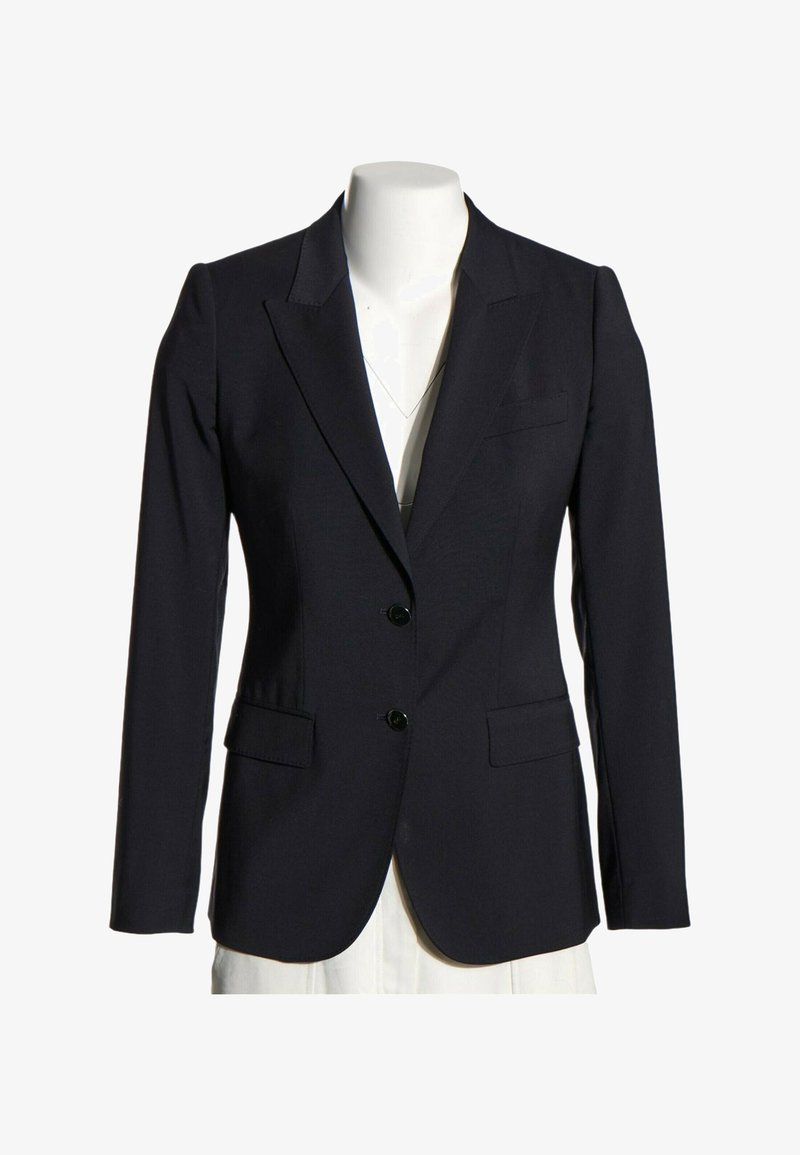 Blazer noir sur mesure avec deux boutons à l’avant, revers crantés et poches à rabat présenté sur un torse de mannequin blanc.
