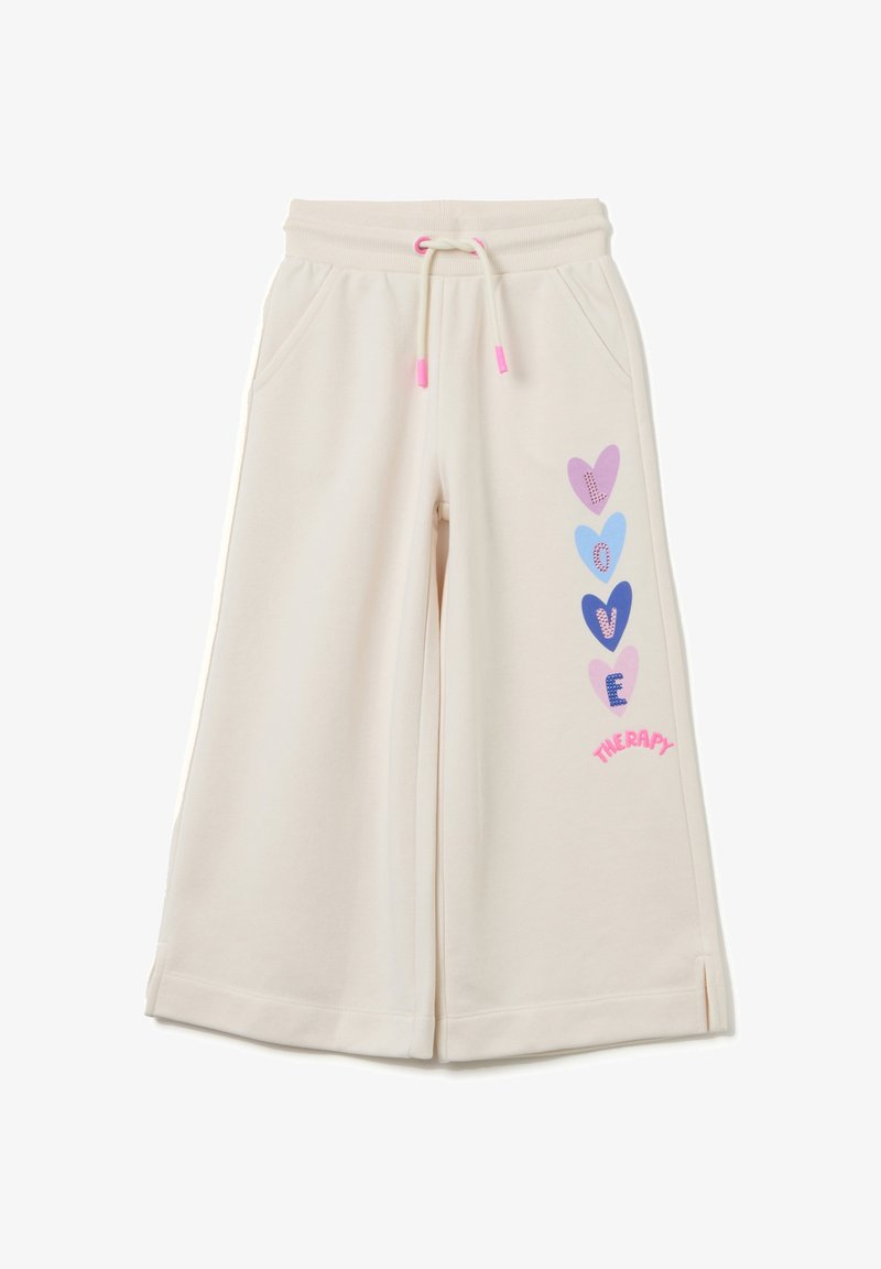 Crème kleurige sweatpants met een relaxte pasvorm, voorzien van een trekkoord in de taille, zijzakken en kleurrijke hartafbeeldingen op één been.