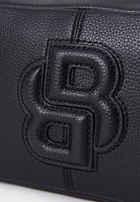 Musta kuvioitu nahkalaukku, jossa on kohokuvioitu kaksois-B-logo. Erottuva pintakuvio ja sävyltään yhtenäinen ompelu sekä sileät yksityiskohdat.