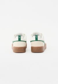 Hvite og grønne sneakers med en teksturert semsket bakdel, gummisåle og logo-detalj på hælen. Rund form med polstret krage.