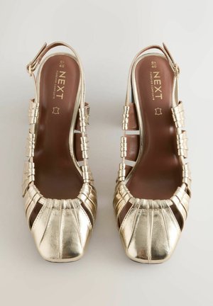 Pair of size 40 gold metallic leather slingback sandals with buckle straps and square toes on a plain background.