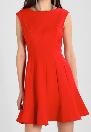 Vestido rojo sin mangas hecho de tejido texturizado, con un corpiño ajustado y una falda acampanada con pliegues, que crea una silueta definida.