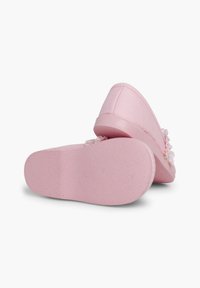 Bottines en tissu rose à enfiler avec une semelle en caoutchouc texturé et des accents floraux à l'avant, dotées d'une finition lisse et d'un design à bout rond.