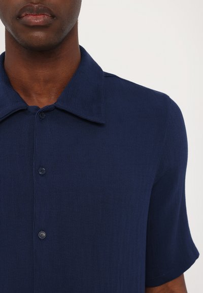 Navy blue short-sleeved shirt made of textured fabric, featuring a button-down front and a classic collar.