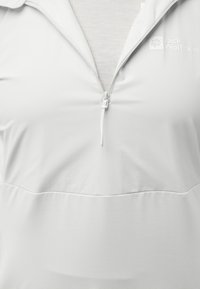 Witte pullover met een halve rits, gemaakt van een lichte stof, met een gladde textuur en een subtiel logo aan de bovenkant aan de linkerkant.