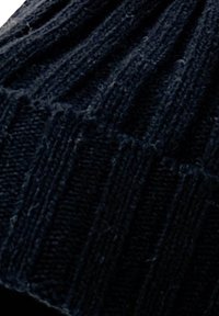 Beanie lavorato a maglia in lana blu scuro, con una texture a costine e un risvolto. Tessuto morbido e flessibile per calore e comfort.
