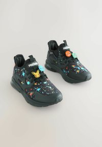 Sorte sneakers med farverigt sprøjtetryk, der har tekstureret materiale og tre legende karaktervedhæng på snørebåndene.