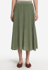 Fållad midiklänning i ljusgrön med subtil glans. Elastisk midja, flödande form och en mjuk textur. Skorna är bruna lägenheter.