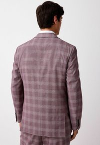 Helllila karierter Blazer mit Reverskragen und zwei Knöpfen, aus strukturiertem Stoff und dekorativen schwarzen Knöpfen an den Ärmeln.
