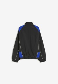 Zwarte jas met blauwe schouder- en zijpanelen, elastische cuffs en zoom, en witte pipingdetails, getoond vanaf de achterkant op een witte achtergrond.