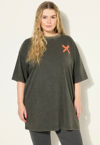 Übergröße dunkelolivgrünes T-Shirt, aus weichem Stoff gefertigt, mit einem gebürsteten orangefarbenen 'X'-Design auf der linken Brust und lockerer Passform.