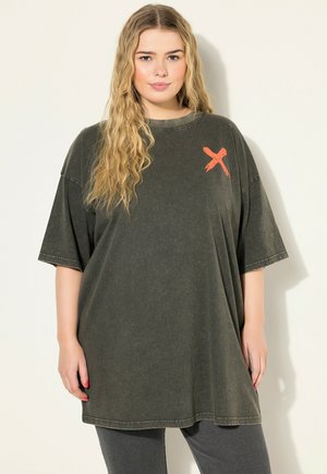 Oversized donker olijfgroene T-shirt, gemaakt van zachte stof, met een geborsteld oranje 'X'-ontwerp op de linkerborst en een ontspannen pasvorm.