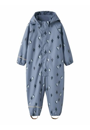 Combinaison de pluie bleue pour enfants avec capuche, imprimé petits pingouins noirs et blancs sur l’ensemble, poignets élastiques et bretelles de chevilles.