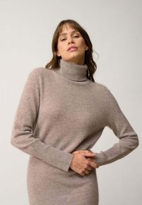 Maglione dolcevita rosa chiaro in morbido tessuto testurizzato; design aderente con maniche lunghe e polsini a costine.