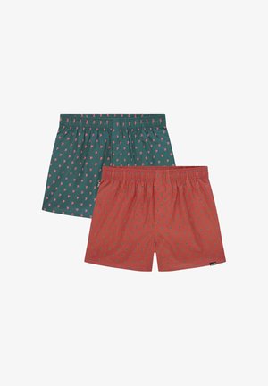 Zwei Paar Boxershorts: eine grüne mit kleinen rosa Mustern, eine rote mit ähnlichen Designs. Beide verfügen über elastische Taillenbänder und eine lockere Passform.